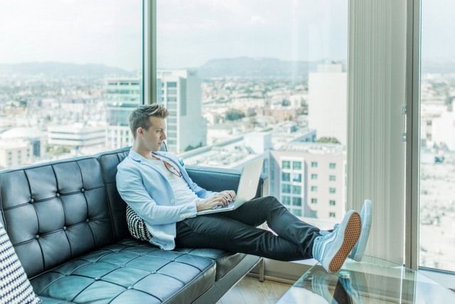 A Man Enjoying His Career Sucess Sitting On A Sofa