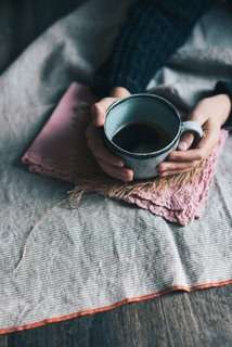 lighbox-image.jpg two hands holding hot black coffee
