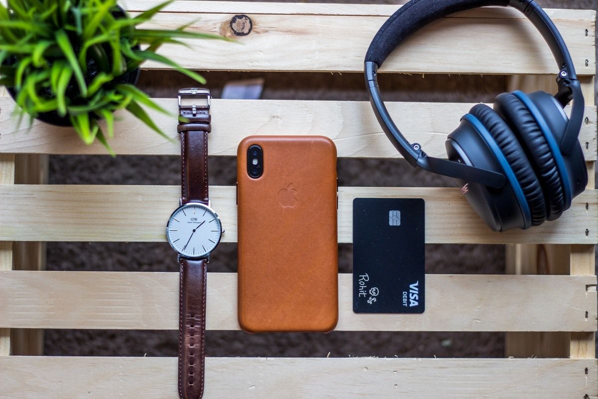 A Table With A Credit Card, Iphone, Watch And Headphones. Featured Image Of How Does Credit Cards Work.