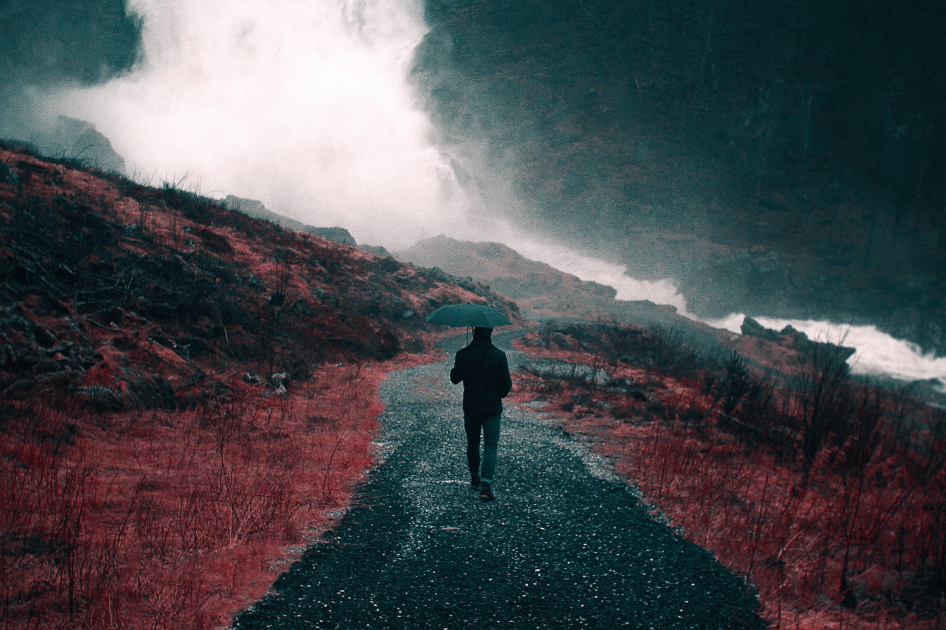 A Man Walking On An Empty Road With An Umbrella In Lazy Dribble